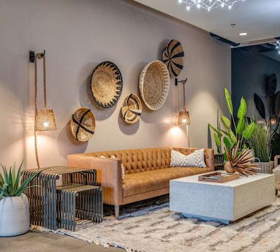 a living room with couches and chairs and baskets on the wall