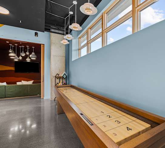 A shiny wood table with numbers 1-4 on it is in the middle of a room.