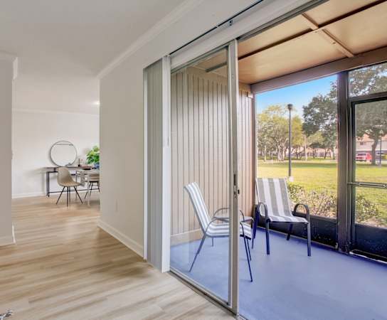 a living room with sliding glass doors and a table and chairs