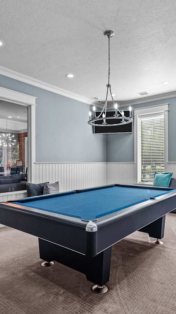 A pool table in a room with a mirror on the wall.  at Eagles Landing, Ammon, ID