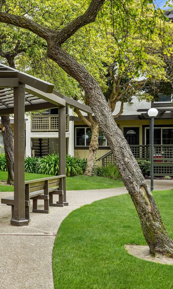 a park with a gazebo and benches in front of a building
