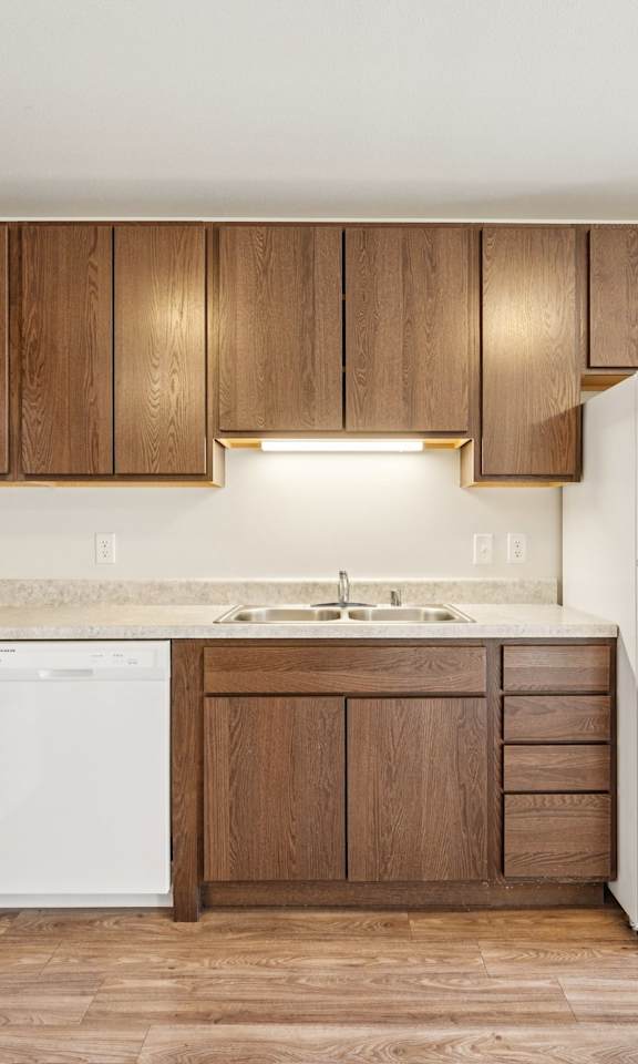 A kitchen with white appliances and wooden cabinets.