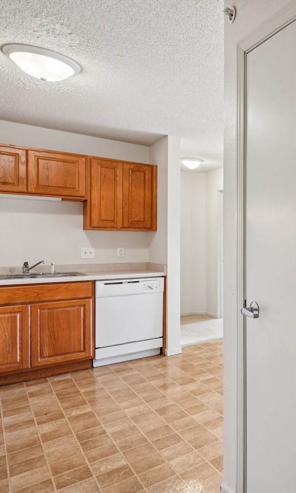 A kitchen with white appliances and wooden cabinets.