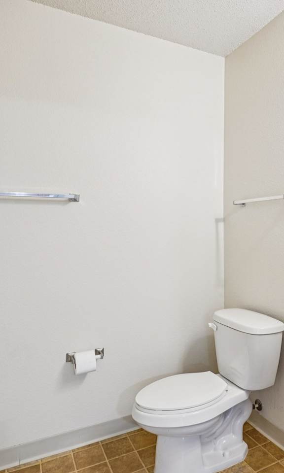 A white toilet sits next to a sink in a small bathroom.