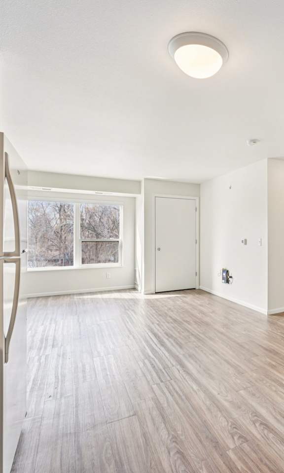 A spacious room with wooden floors and white walls.