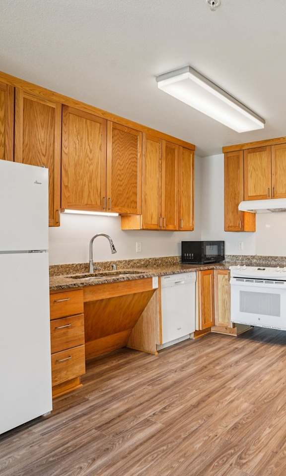 A kitchen with wooden cabinets and a white refrigerator.