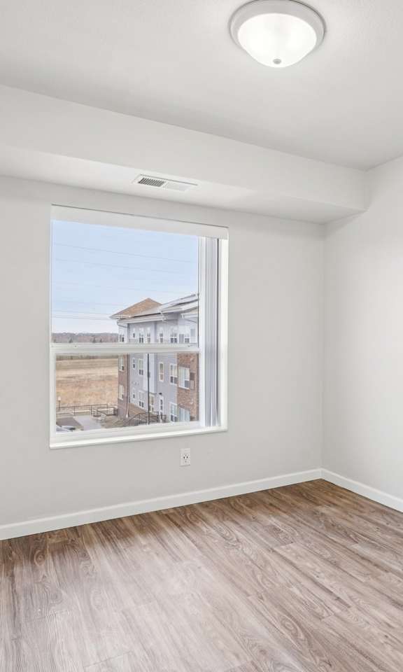A room with a window and a picture on the wall.