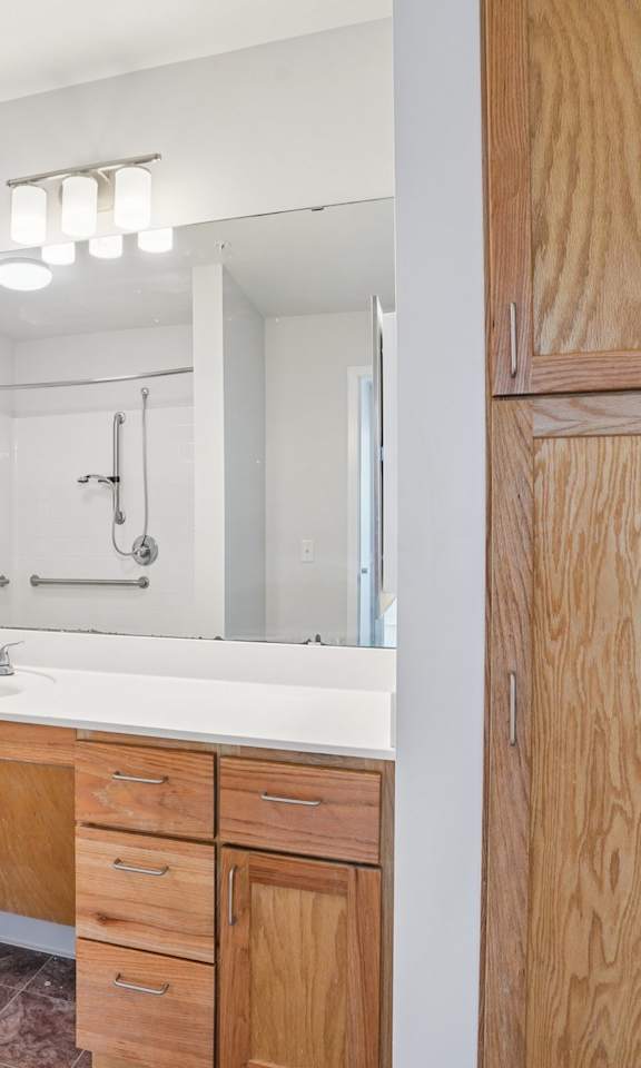 A bathroom with a toilet, sink, and wooden cabinet.