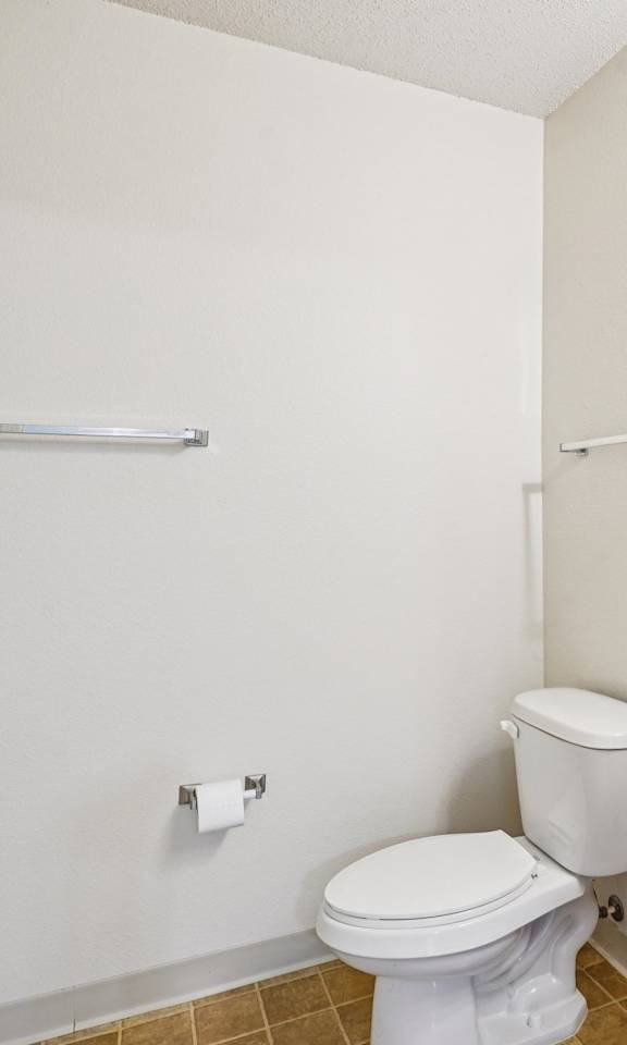 A white toilet sits next to a sink in a small bathroom.