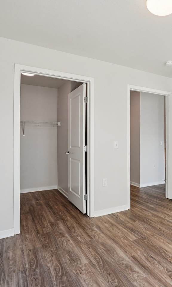 A room with a white door and a white wall with a light on.