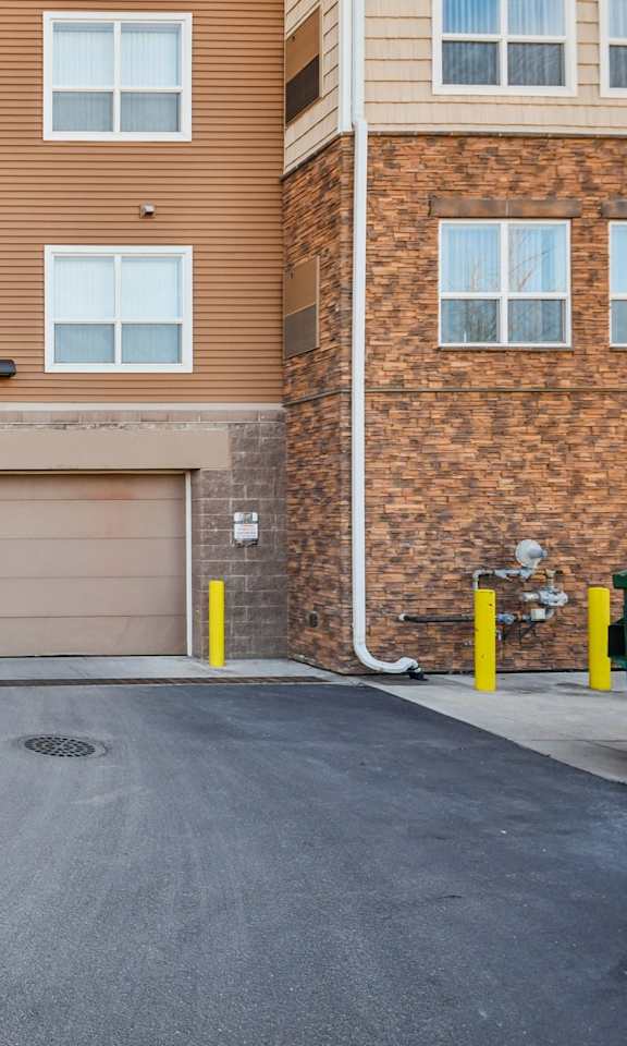A brown brick building with a garage door in the middle.
