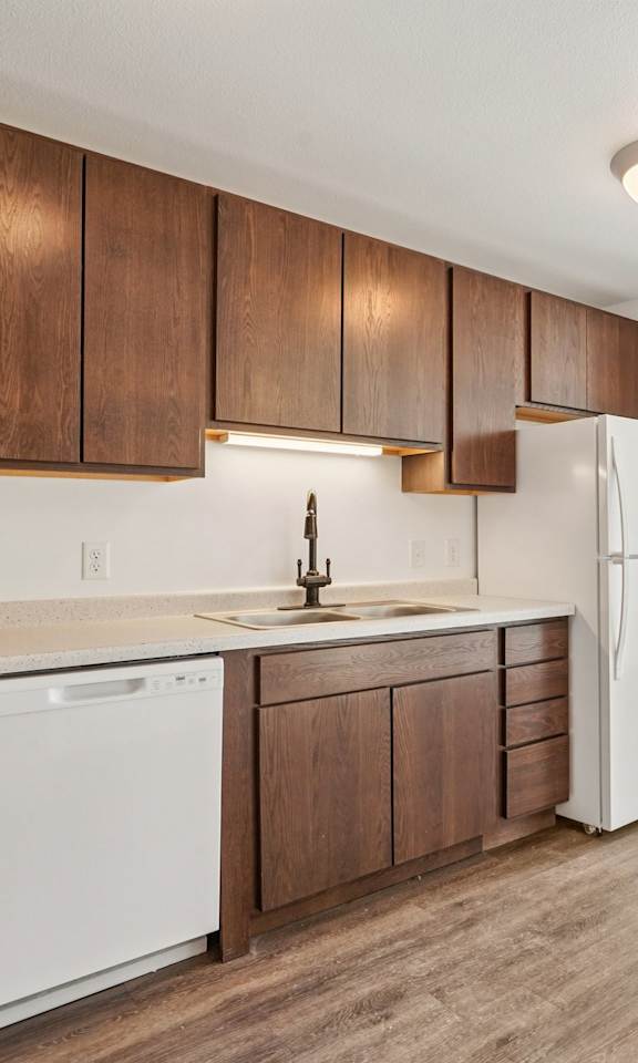 A kitchen with wooden cabinets and white appliances.