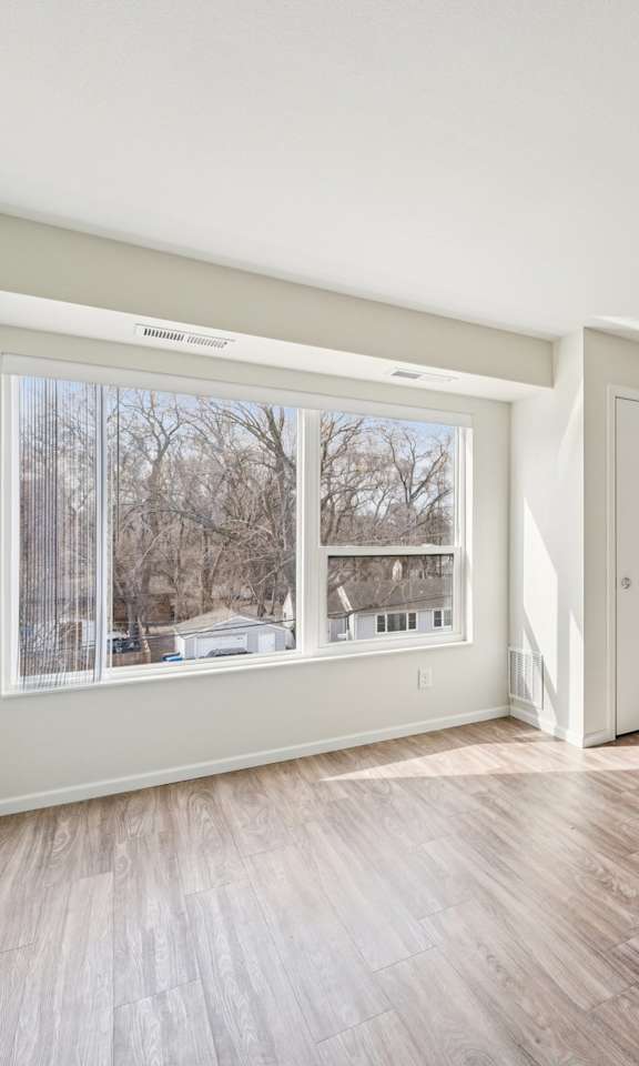 A room with wooden floors and a large window.
