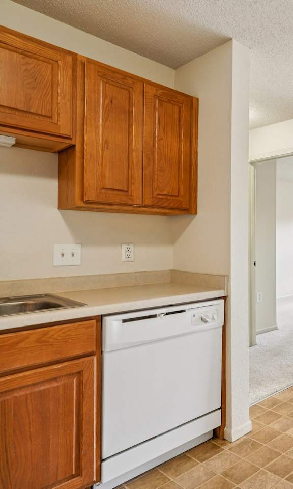 A kitchen with white appliances and wooden cabinets.
