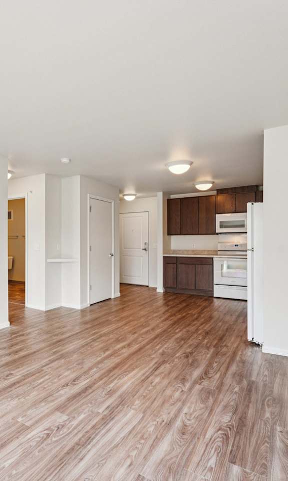 A room with a white wall and a brown floor.