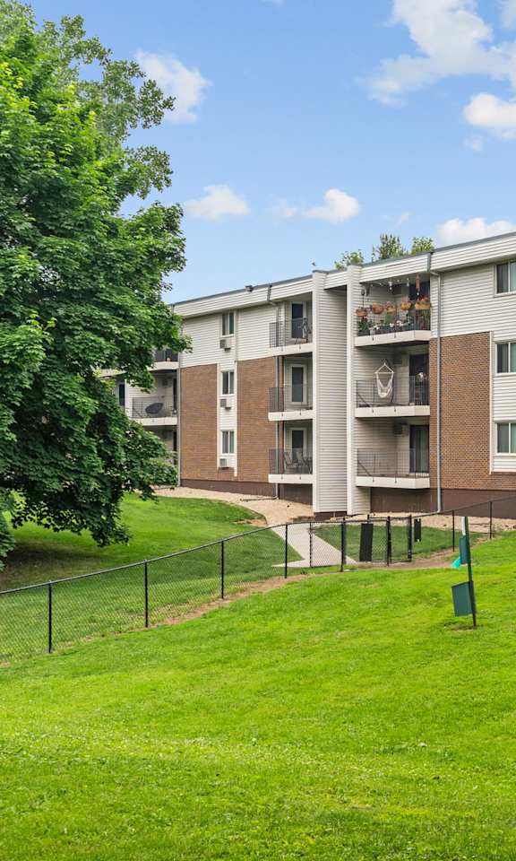 A large apartment complex with a green lawn in front.