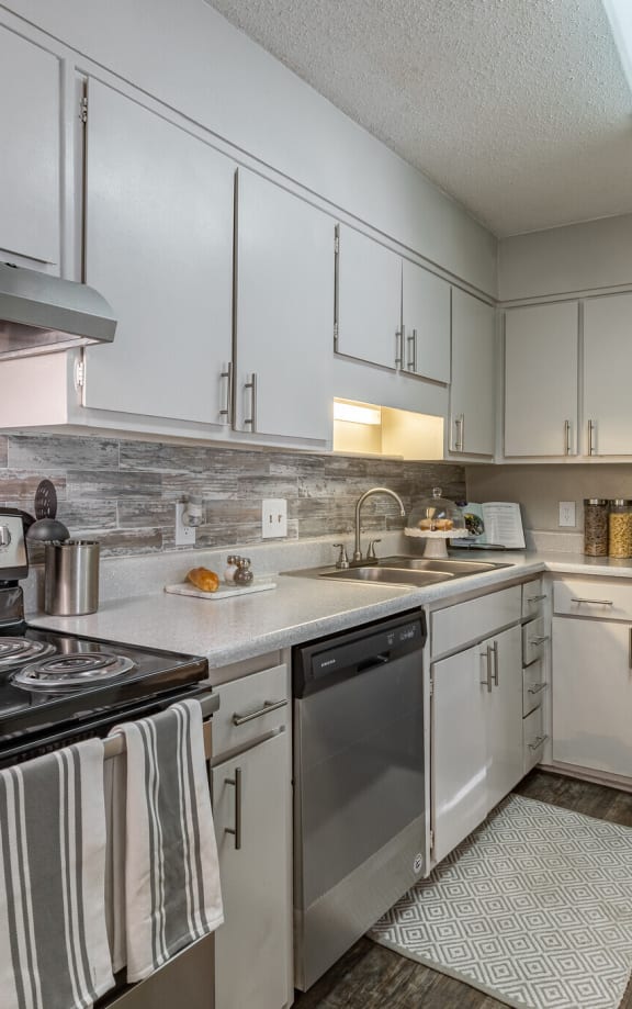 a kitchen with white cabinets and stainless steel appliances at Tucker Square, Georgia