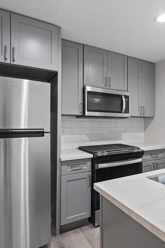 A modern kitchen with white cabinets and stainless steel appliances.