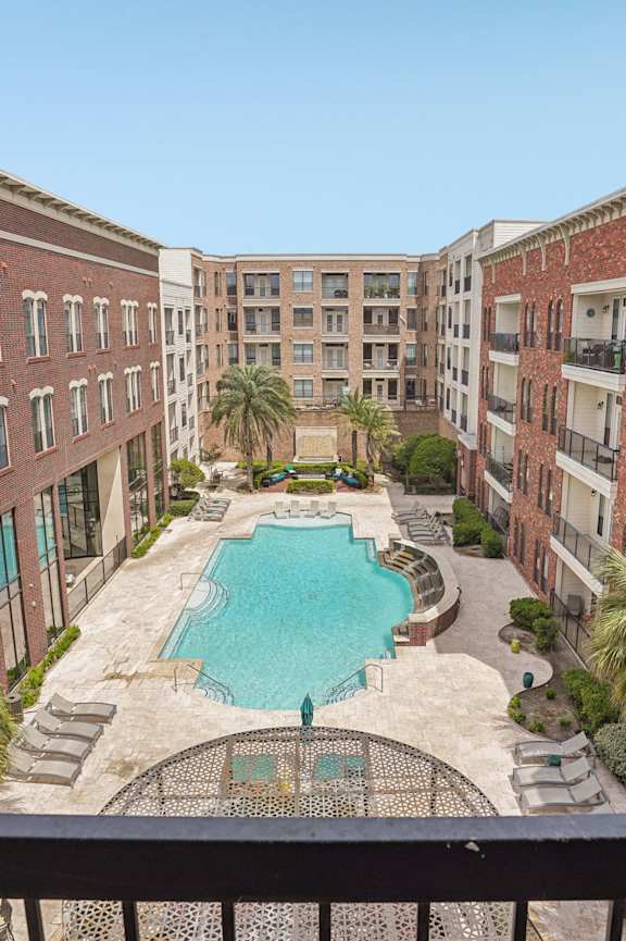A view of a pool from a balcony of a building.
