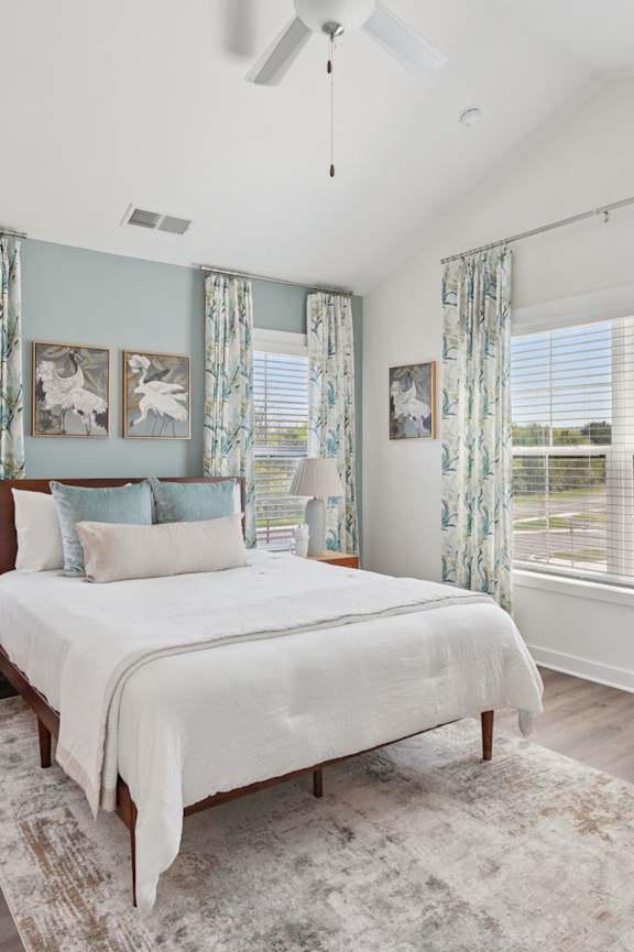 A bedroom with a large bed and a chair.