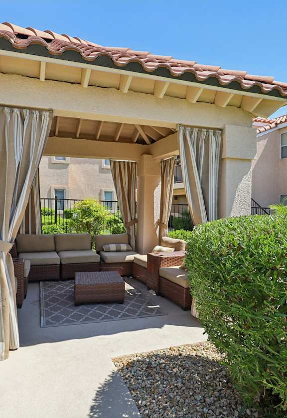 A gazebo with couch to relax near the pool