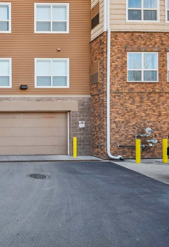 A brown brick building with a garage door in the middle.