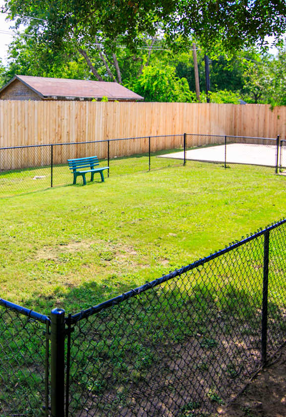 a fenced in backyard with a pool and a bench