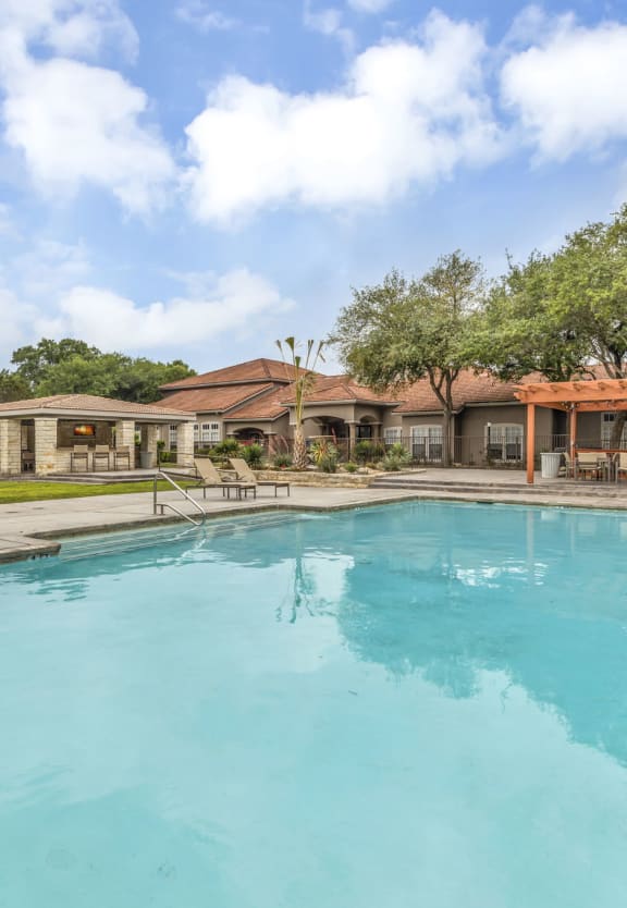 the swimming pool at 1861 muleshoe road with a house in the background at River Stone Ranch, Texas, 78749