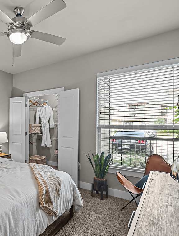 a bedroom with a large bed and a ceiling fan