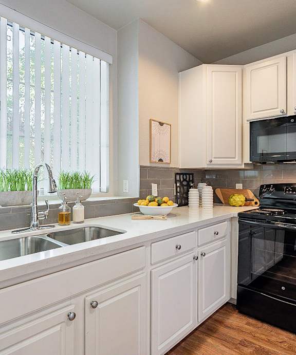 A kitchen with white cabinets and a black oven.at Palazzo Townhomes, Phoenix, AZ