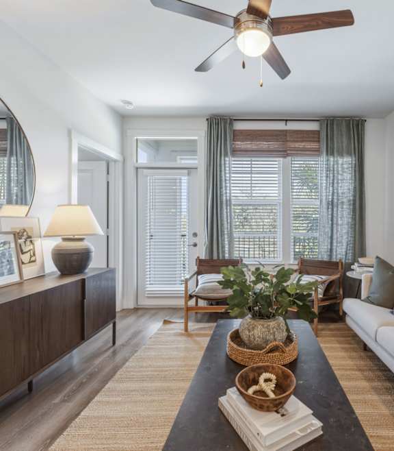 A modern living room with a stone fireplace and a large open space at Waterleaf at Neely Ferry Apartments, Simpsonville, SC