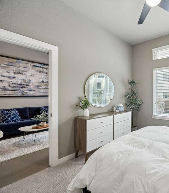 A bedroom with a large bed and a ceiling fan.