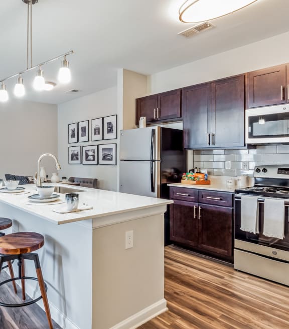 an open kitchen and living room with a large island with stools at The Atlantic Mountain Island, Charlotte