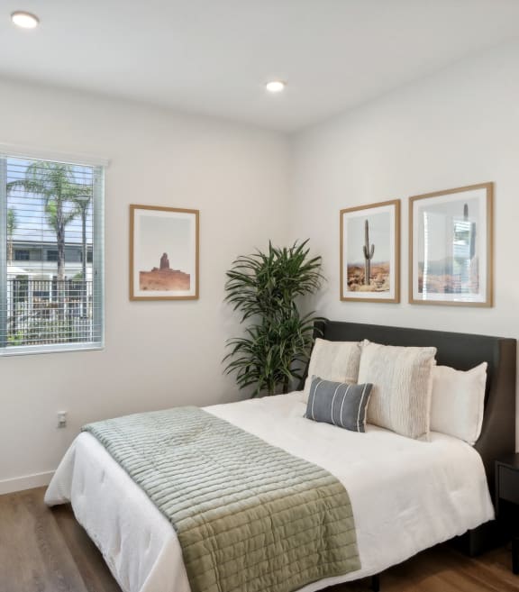 a balcony with a table and chairs and a umbrella at The Max on Jefferson Apartments, Murrieta, California