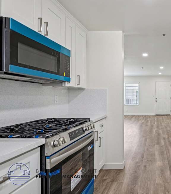A well-lit, modern kitchen and living room with a dining area.