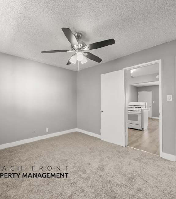 A room with a ceiling fan and a carpeted floor.