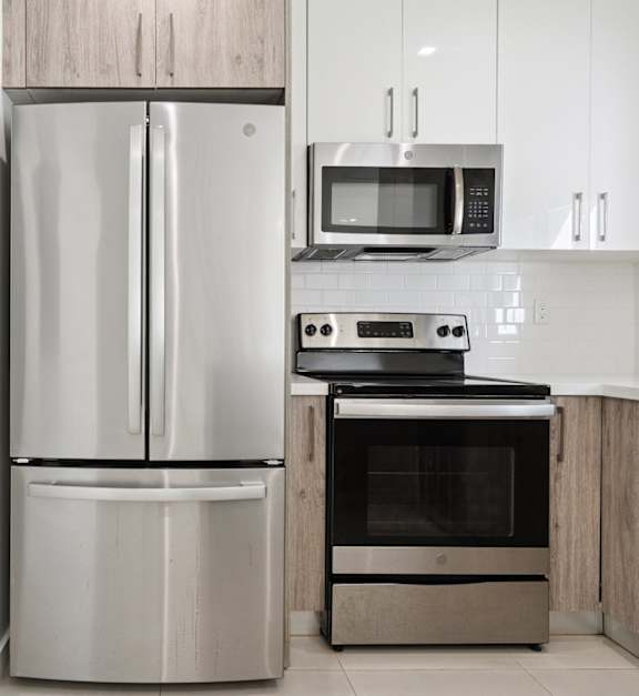 A modern kitchen with a stainless steel refrigerator, oven, and microwave.at The Villages at Miami Gardens, Florida