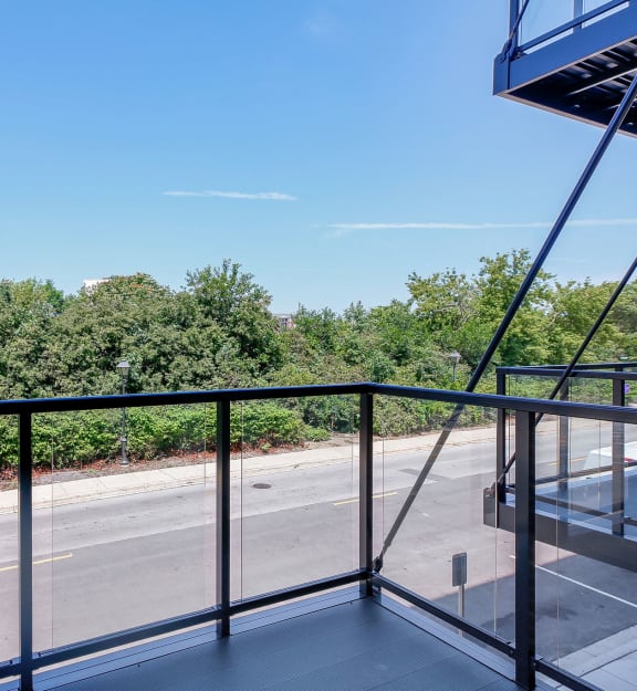 a balcony with a view of a street and trees