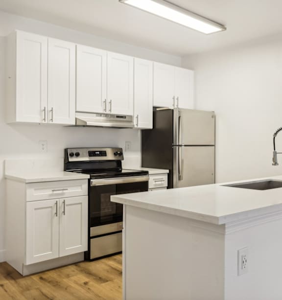 A modern kitchen with a stainless steel refrigerator and a white countertop.