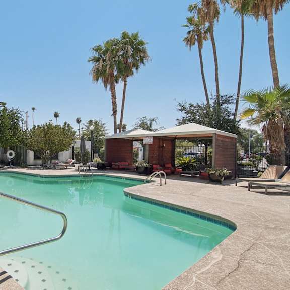 Pool with seating area around at Palm Villas, Arizona