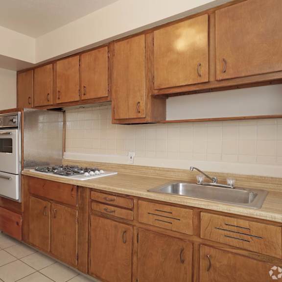 A kitchen with wooden cabinets and a white refrigerator.