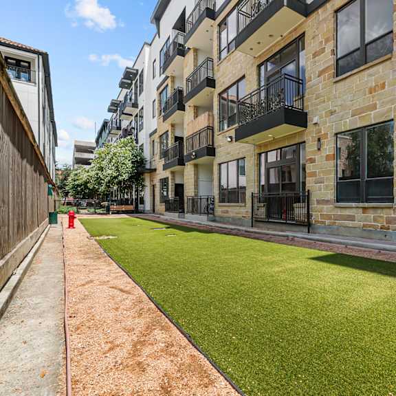 an apartment building with a green lawn in front of it