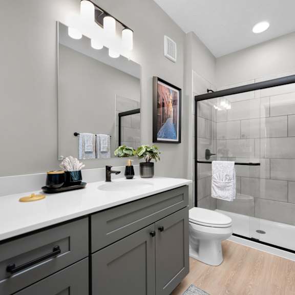 A bathroom with a white countertop and a white toilet.