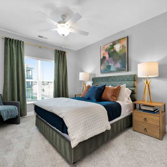 A bedroom with a bed, chair, and a painting on the wall.