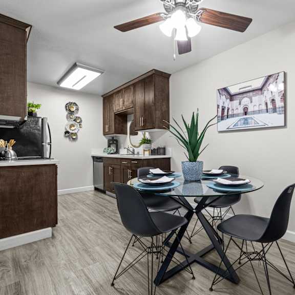 A kitchen with a dining table and chairs.