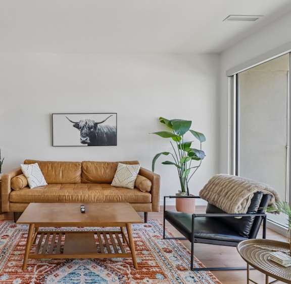 A living room with a yellow couch and a coffee table.