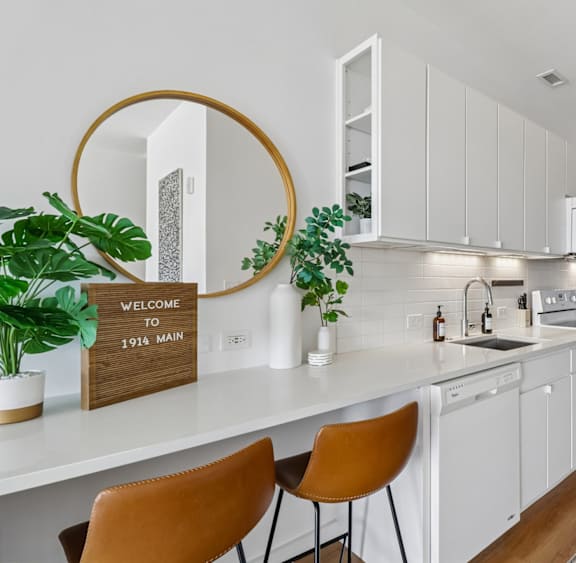 A kitchen with white cabinets and a wooden floor.