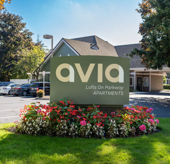 Avia lofts on parkway apartments sign with flowers in front. at AVIA Lofts on Parkway Apartments, Vancouver, 98662