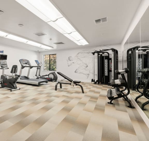 A gym with a variety of equipment including treadmills, weights, and exercise machines. at AVIA Lofts on Parkway Apartments, Vancouver, 98662