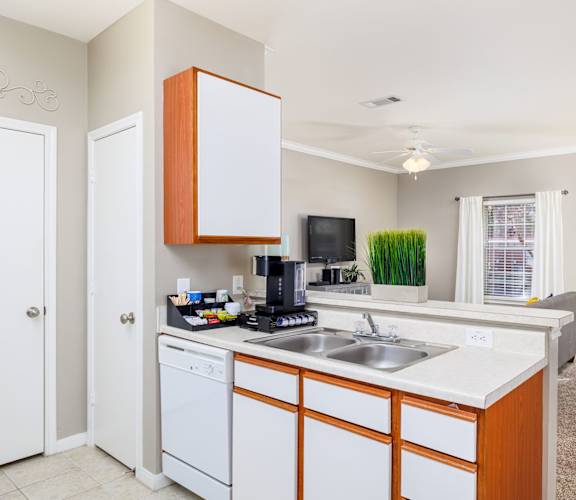 A kitchen with white cabinets and a white dishwasher. at Clear Creek Meadows Apartments, Texas
